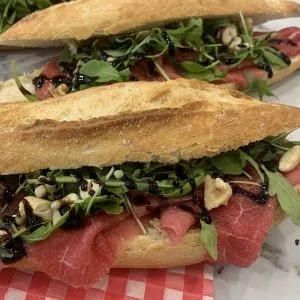 Broodjes bresaola met rucola op een rood geruit papiertje