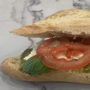 Broodje caprese met tomaat, mozzarella, basilicum en pesto