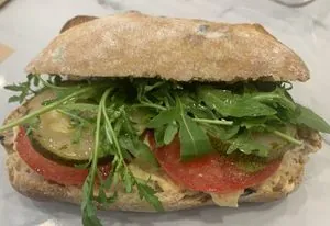 Broodje vega met houmous, courgette, tomaat en rucola