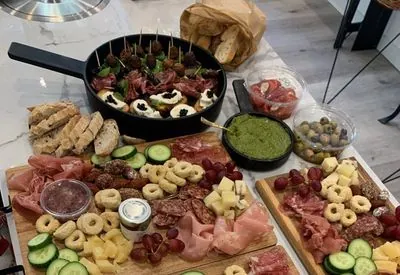 Planken met vleeswaren, kaas, druiven, komkommer en taralli